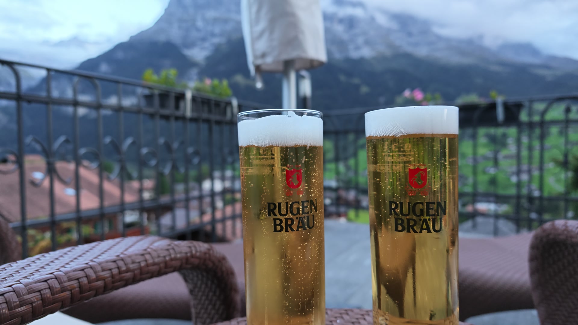 山並みを背景にテーブルに並ぶ2杯のビール